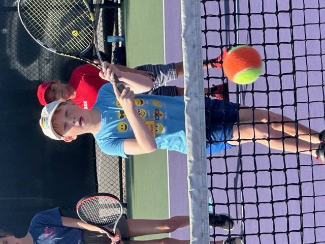 kid hitting orange ball